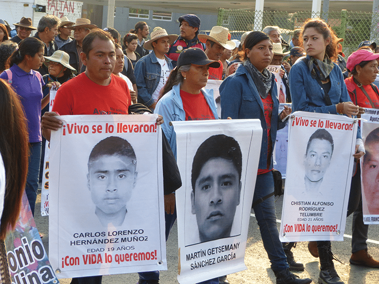 Maximino Hernández (in red), father of Carlos Lorenzo, holds a sign that reads: "Taken alive! We want him back alive!" Photo: Témoris Grecko