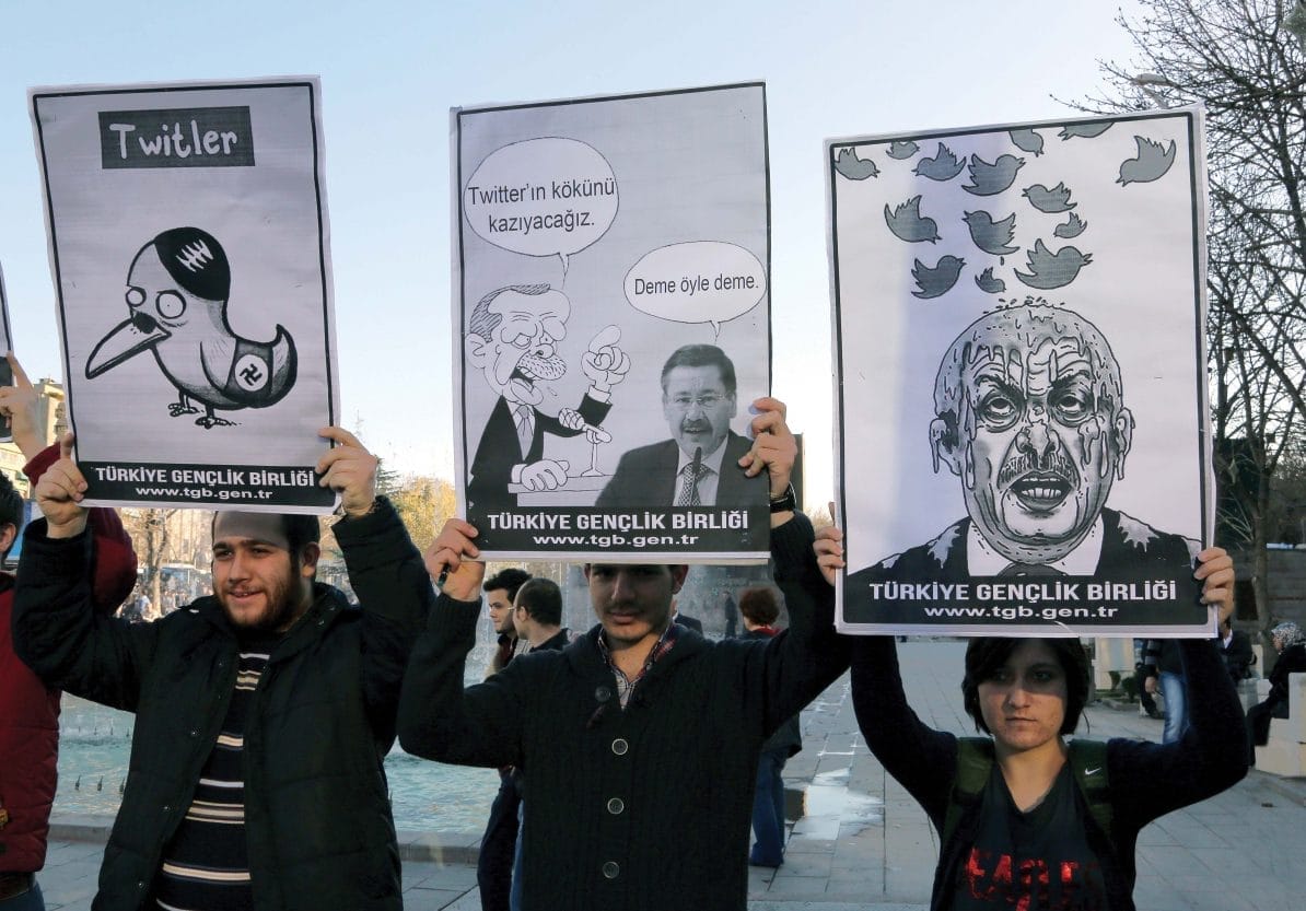 Members of the Turkish Youth Union hold cartoons depicting Turkey's Prime Minister Recep Tayyip Erdogan during a protest against a ban on Twitter, in Ankara, Turkey