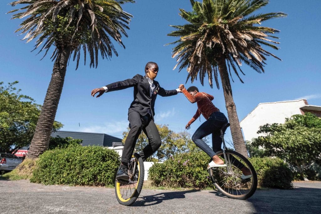 Practising using unicycles in the college grounds between classes