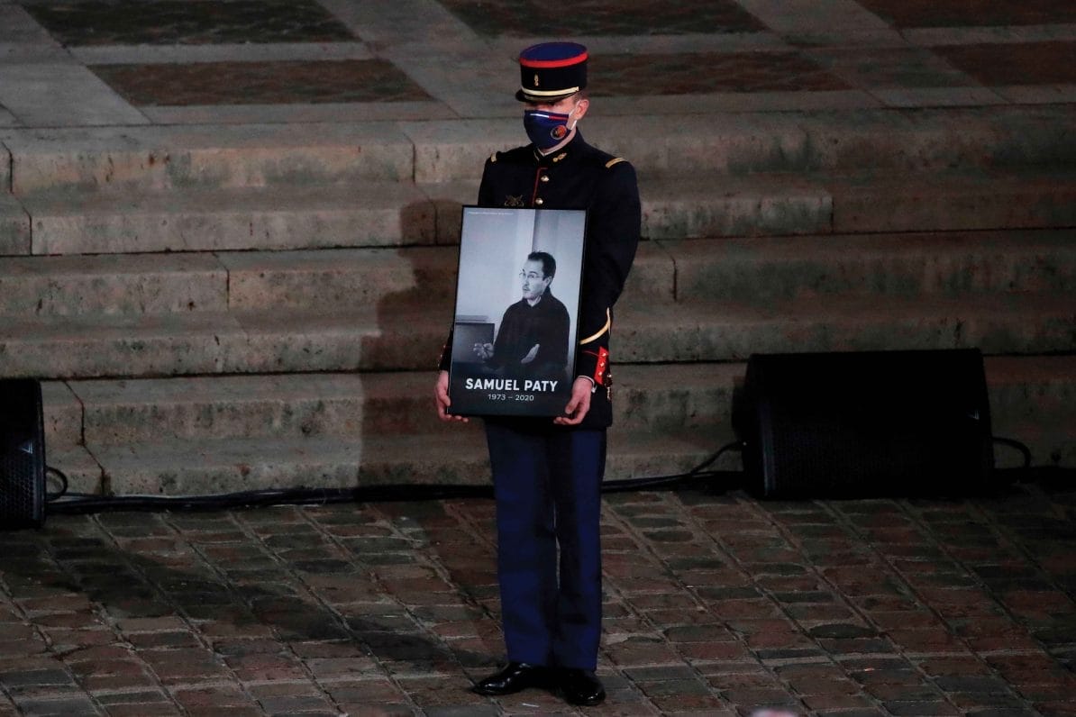A French Republican guard holds a portrait of Samuel Paty at the Sorbonne University in Paris on 21st October 2020, during a national homage to the teacher
