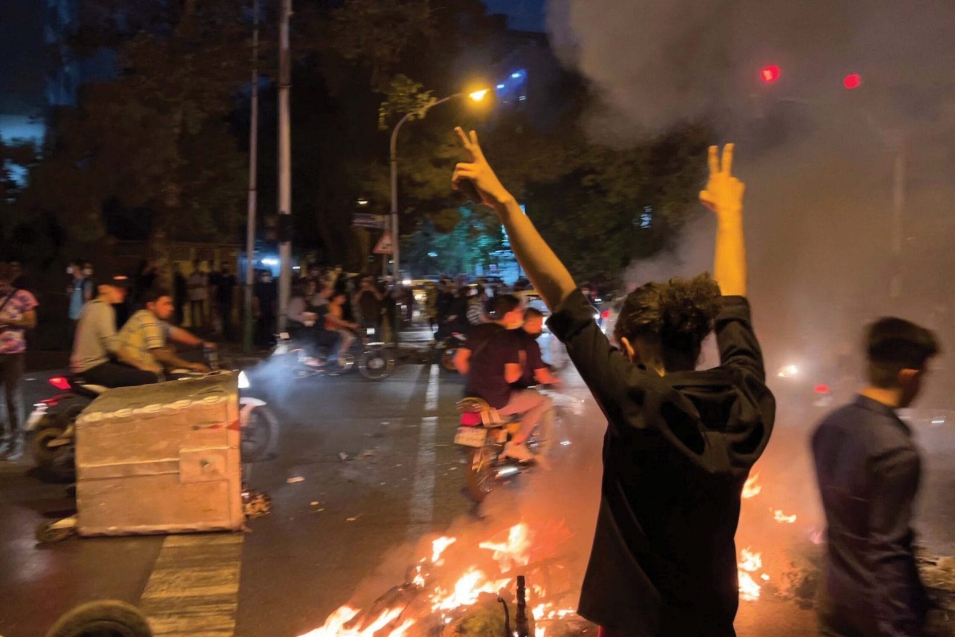 A demonstrator raises his arms and makes the victory sign during a protest for Mahsa Amini in Iran, 19th September 2022