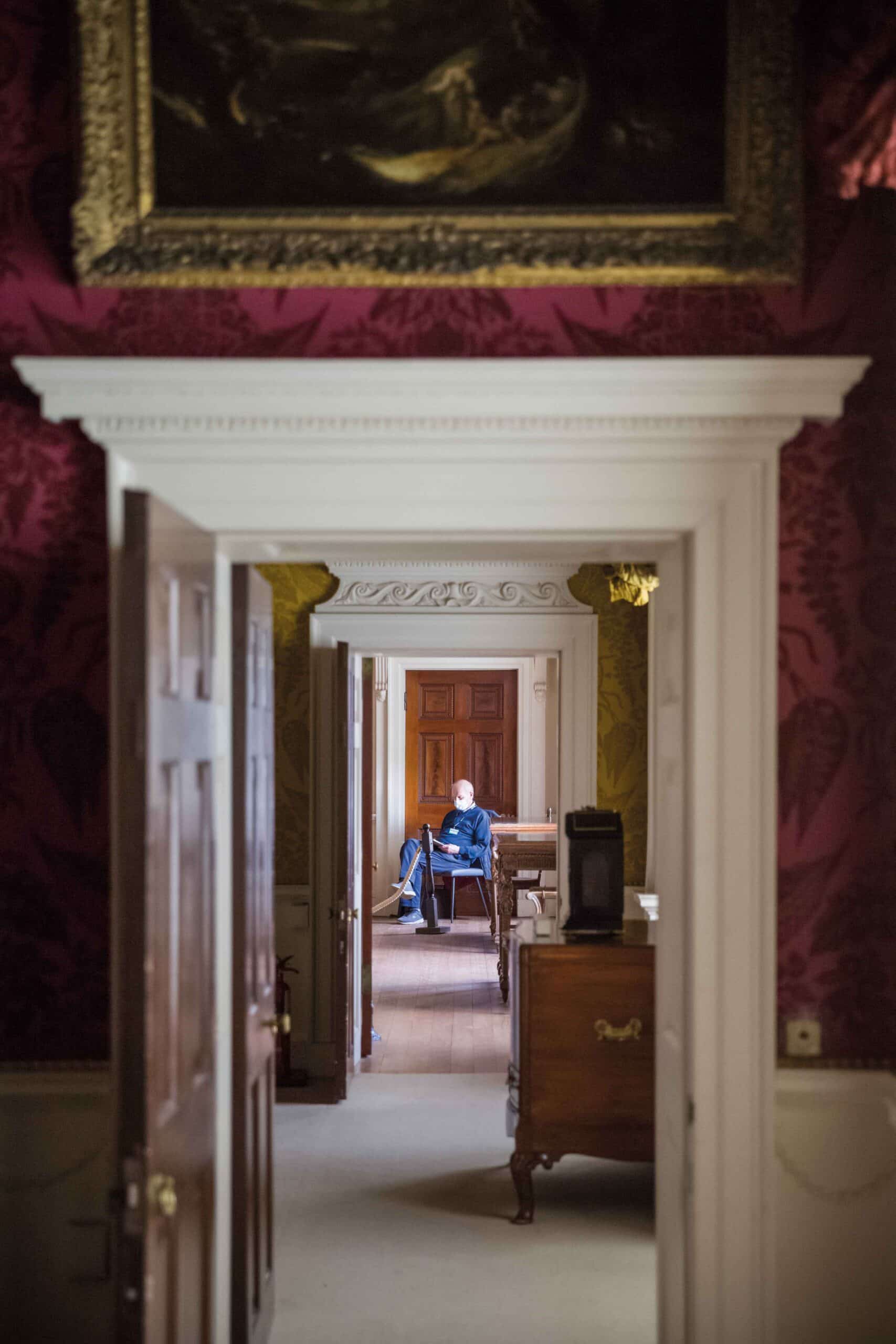 A volunteer seen through an enfilade of rooms at Nostell Priory, one of the properties referenced in the National Trust’s interim report on links between its properties and colonialism
