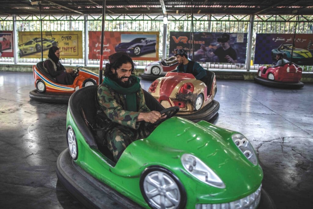 A Taliban fighter drives a bumper car in an amusement park in Kabul