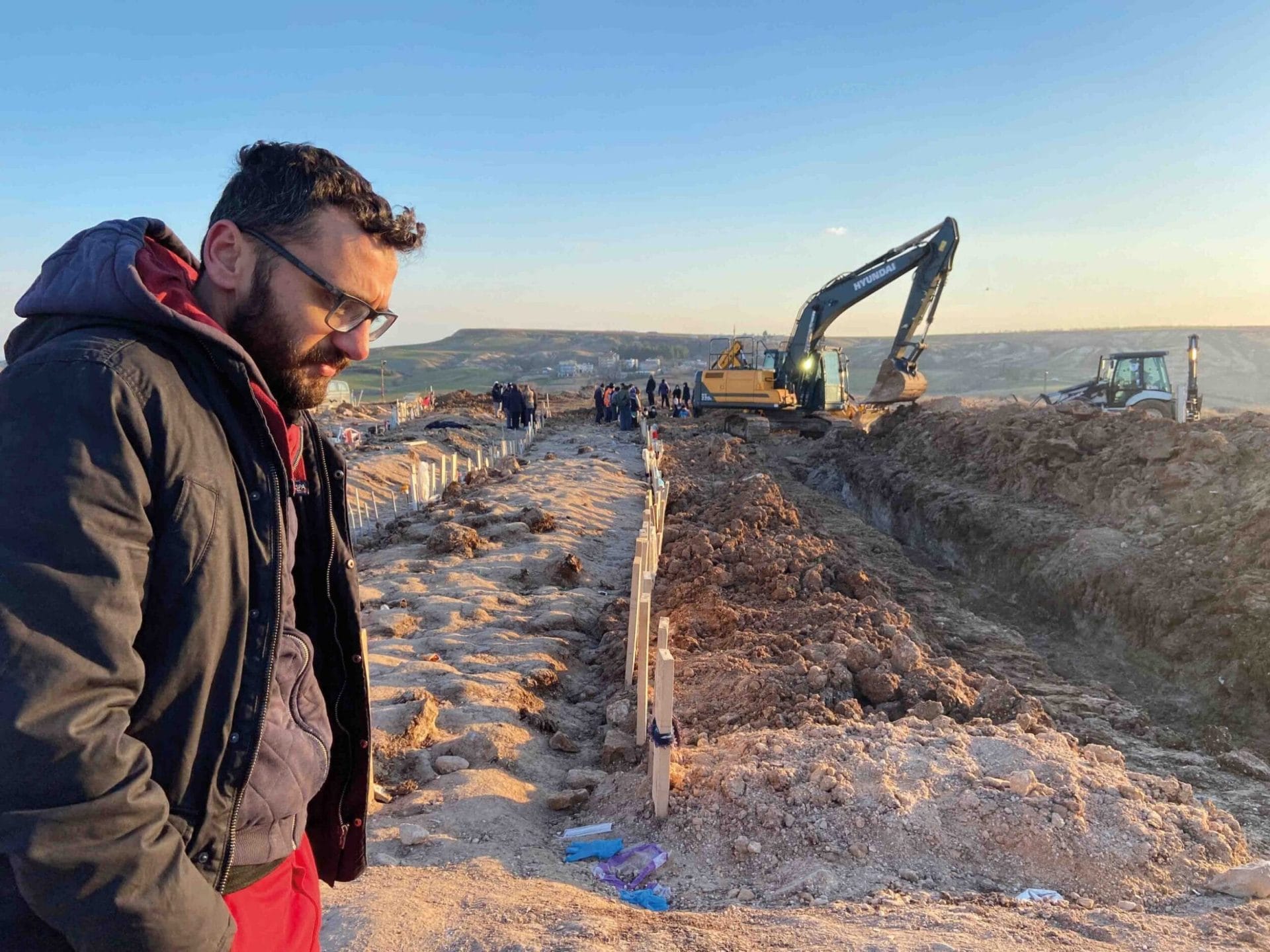 Ahmet Eren searches for the bodies of his family members among the mass graves at a cemetery in Adiyaman 