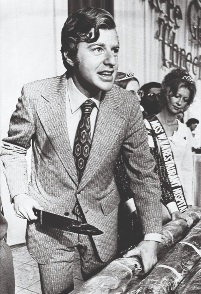 Jerry Springer cutting a large sandwich during a convention of restaurant operators in February 1974. He would go on to become mayor of Cincinnati in 1977