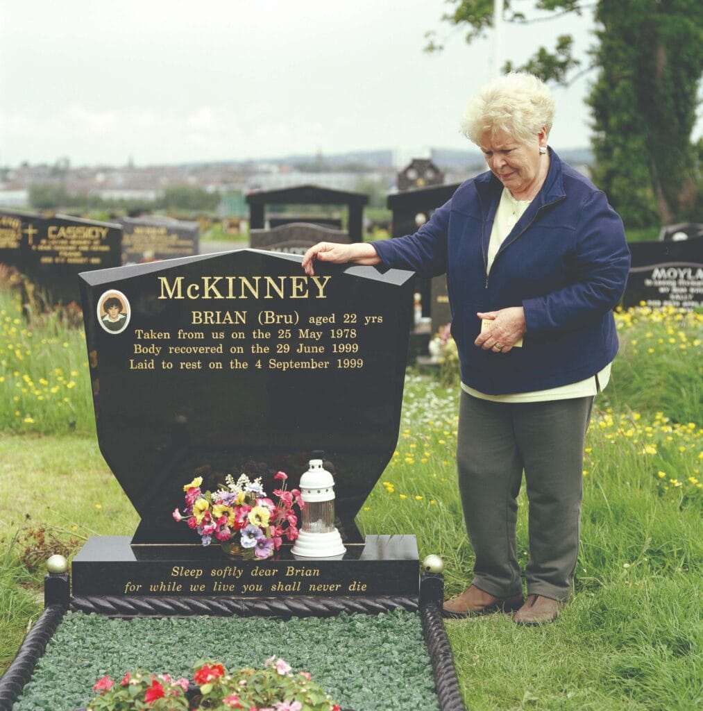 Margaret McKinney photographed beside the grave of her son, Brian. Despite facing threats, McKinney broke the silence surrounding ‘the disappeared’